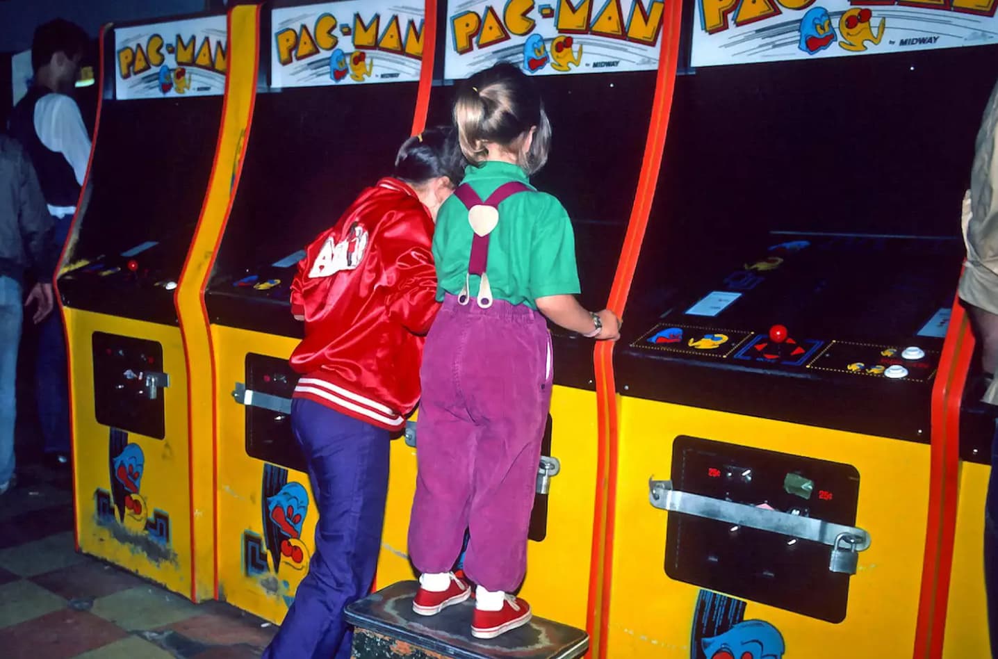 Kids play Pac-Man in an arcade, date unknown. 